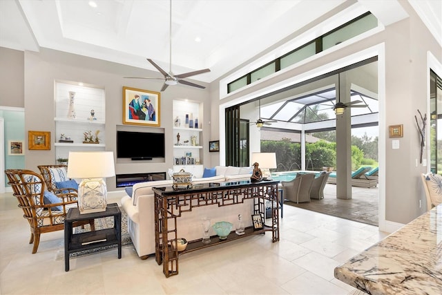 living room with coffered ceiling, a high ceiling, and built in shelves