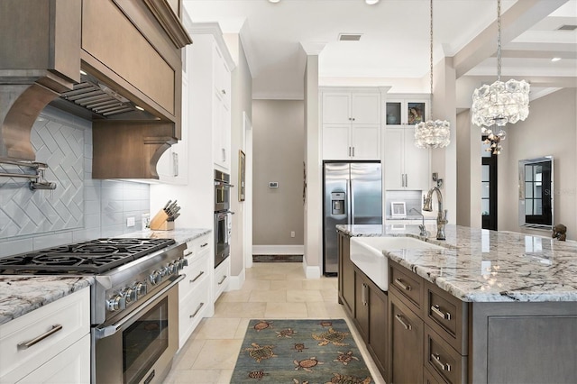 kitchen with white cabinets, stainless steel appliances, sink, hanging light fixtures, and a notable chandelier