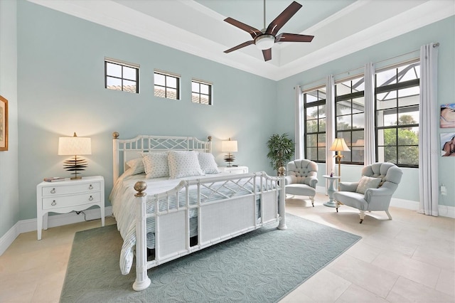 bedroom with ceiling fan, ornamental molding, tile patterned floors, and a tray ceiling