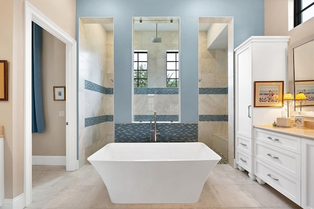 bathroom featuring vanity, tile patterned flooring, and a bath