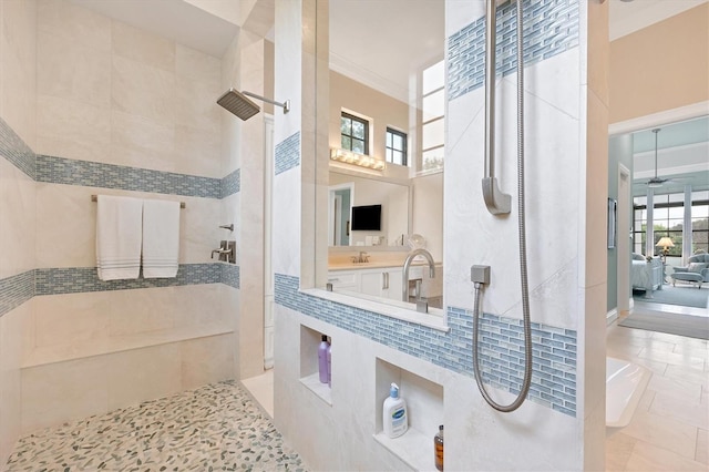 bathroom with sink, a wealth of natural light, and tiled shower