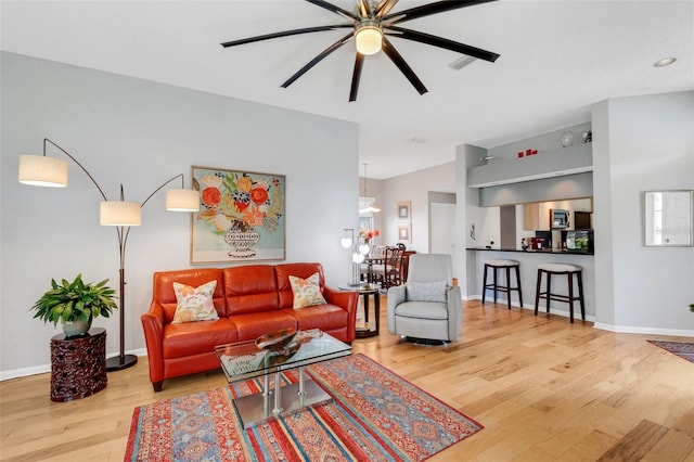 living room featuring ceiling fan and hardwood / wood-style floors