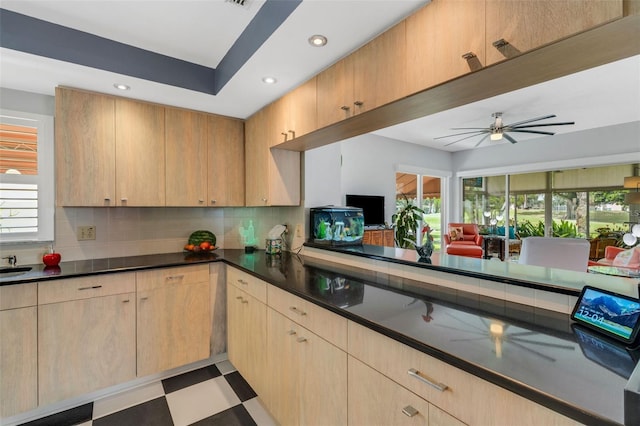 kitchen featuring light brown cabinets, ceiling fan, and decorative backsplash