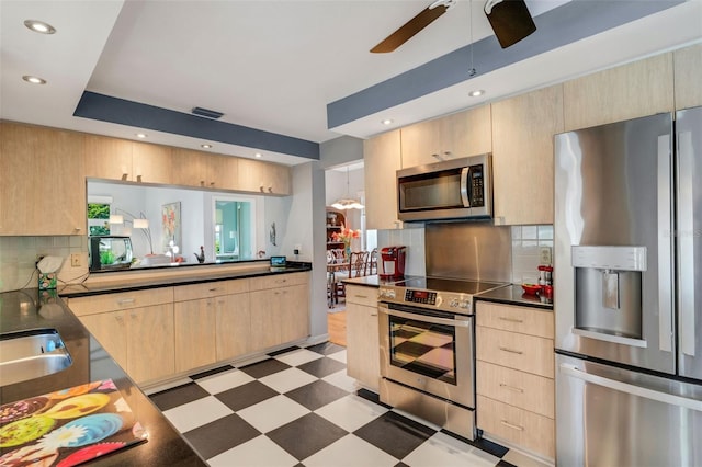 kitchen with backsplash, light brown cabinetry, appliances with stainless steel finishes, and ceiling fan