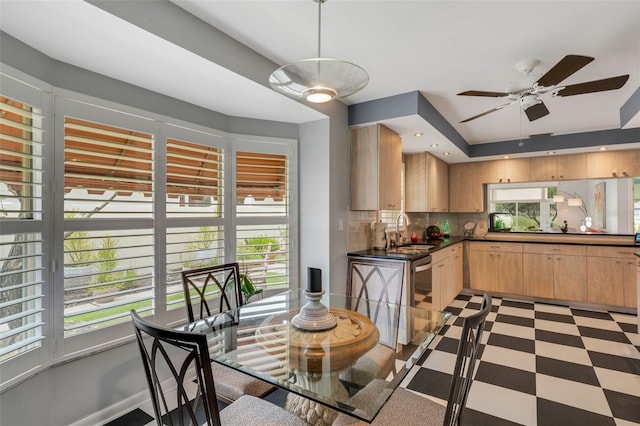 dining space with ceiling fan, plenty of natural light, and sink