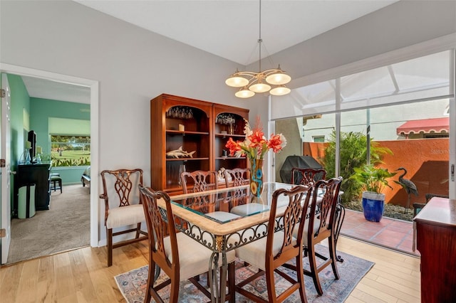 dining space with light wood-type flooring and a notable chandelier