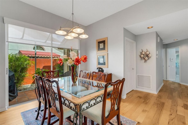 dining area featuring an inviting chandelier and light hardwood / wood-style flooring