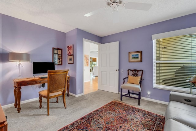 office space with a textured ceiling, ceiling fan, and light carpet