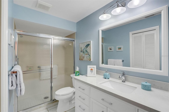 bathroom with tile patterned flooring, vanity, toilet, and a shower with shower door