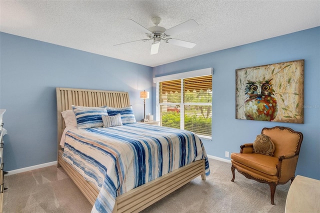 bedroom featuring a textured ceiling, ceiling fan, and light carpet