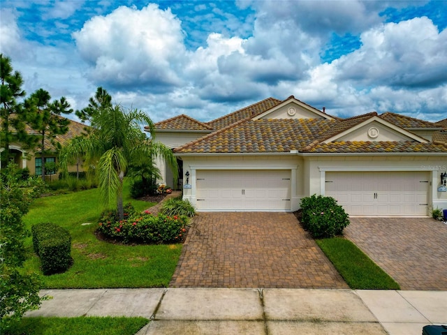 mediterranean / spanish house with a garage and a front lawn