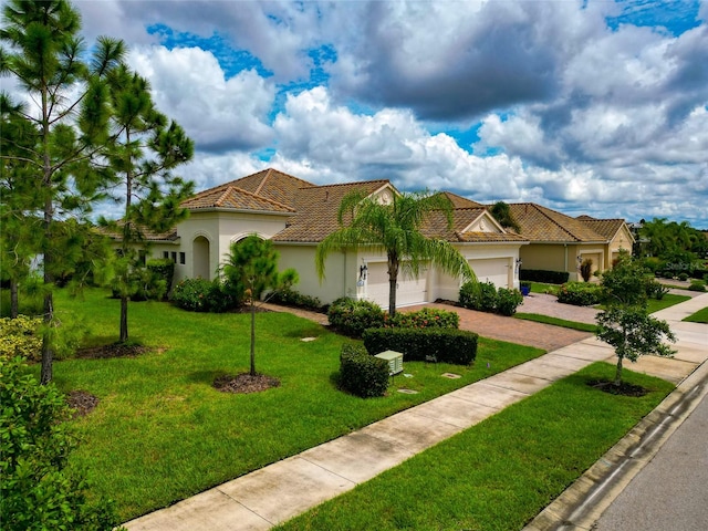 mediterranean / spanish home with a garage and a front lawn