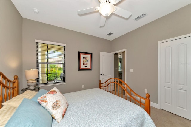 bedroom with light colored carpet, ceiling fan, and a closet