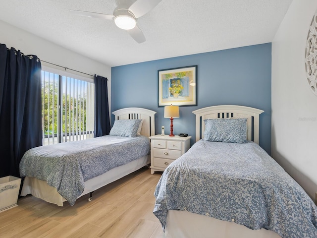 bedroom with ceiling fan, a textured ceiling, and light wood-type flooring