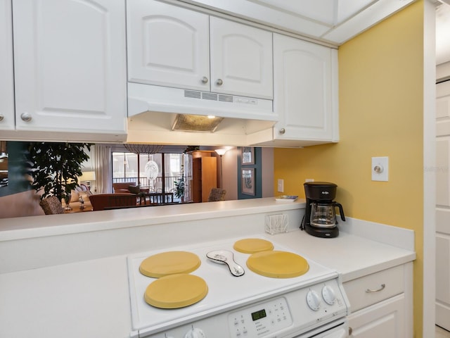 kitchen featuring white cabinets and white range