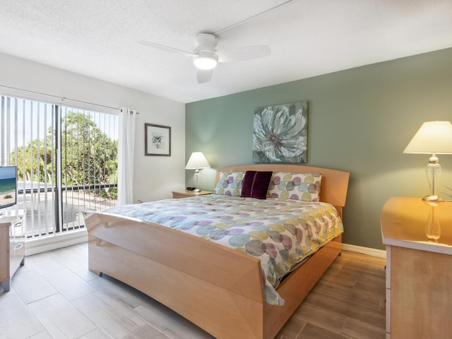 bedroom featuring ceiling fan, access to exterior, a textured ceiling, and light hardwood / wood-style floors