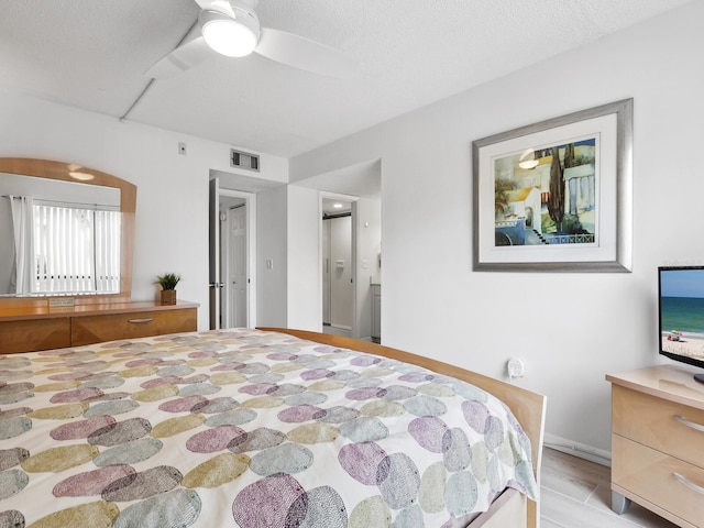 bedroom with light hardwood / wood-style floors, ceiling fan, and a textured ceiling