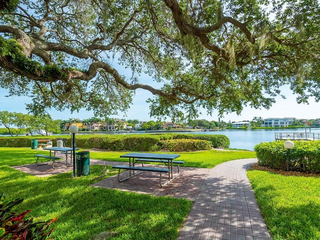 view of community with a lawn and a water view