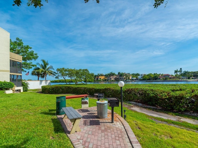 surrounding community with a yard and a water view