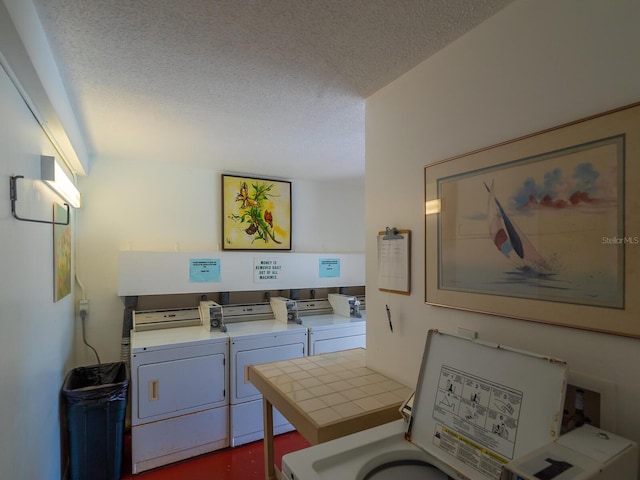 washroom featuring a textured ceiling and washing machine and clothes dryer