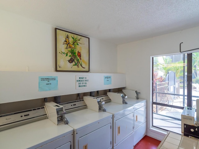 washroom with washer and clothes dryer, a healthy amount of sunlight, and a textured ceiling