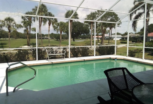 view of swimming pool featuring glass enclosure