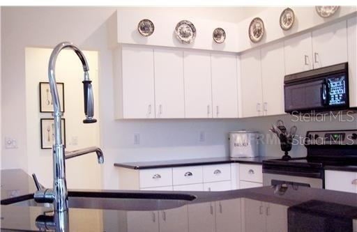 kitchen with white cabinetry and range with electric cooktop