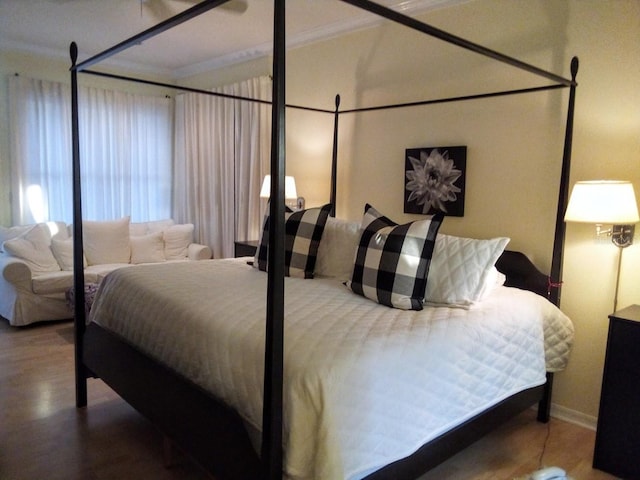 bedroom with ornamental molding and wood-type flooring