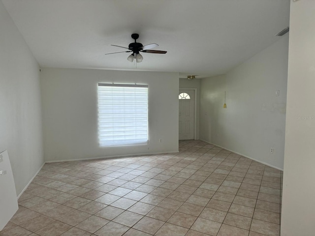 tiled spare room featuring ceiling fan