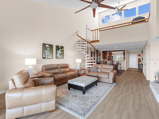 living room featuring ceiling fan and a towering ceiling