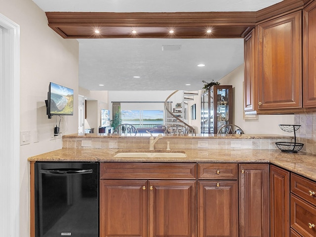 kitchen with light stone countertops, black dishwasher, kitchen peninsula, and sink