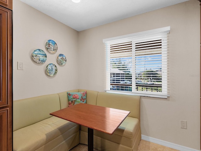 tiled dining room featuring breakfast area and a healthy amount of sunlight