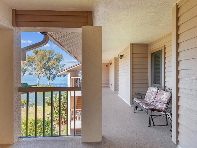 view of patio / terrace with a water view and a balcony