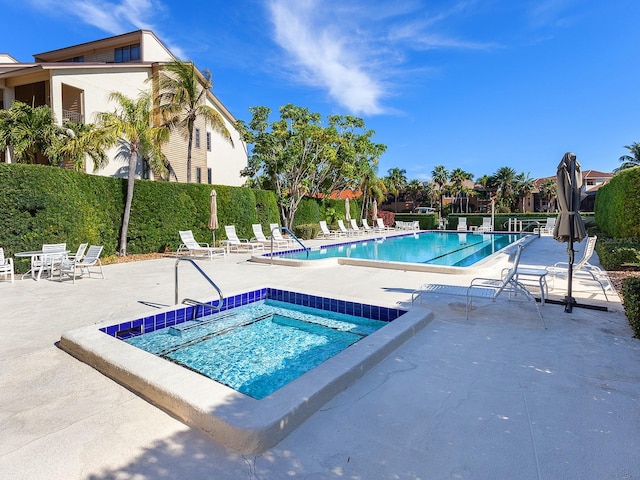 view of swimming pool with a patio area and a hot tub