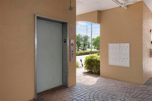 property entrance with elevator and stucco siding