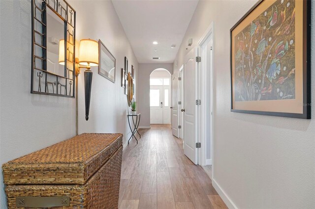 hall with recessed lighting, baseboards, arched walkways, and wood finished floors