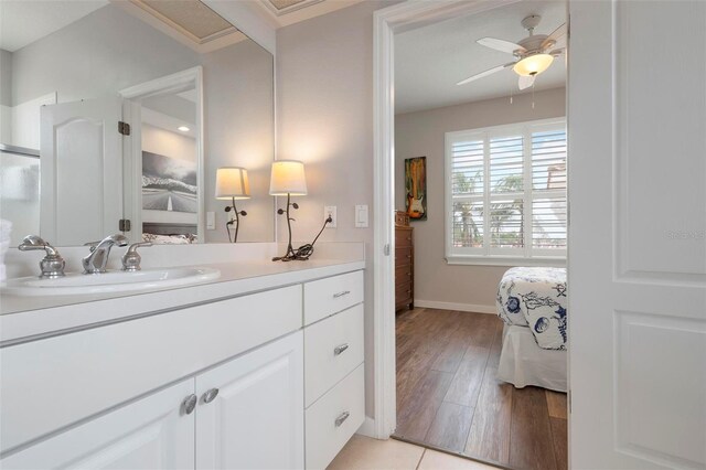 bathroom featuring vanity, wood finished floors, a ceiling fan, baseboards, and ensuite bath