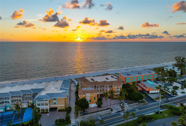 aerial view at dusk featuring a residential view and a water view