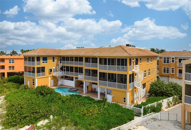 view of property with a community pool and fence