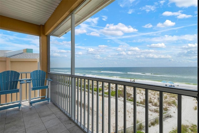 balcony featuring a water view and a beach view