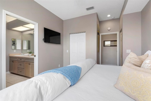 bedroom with visible vents, light tile patterned flooring, recessed lighting, a closet, and connected bathroom