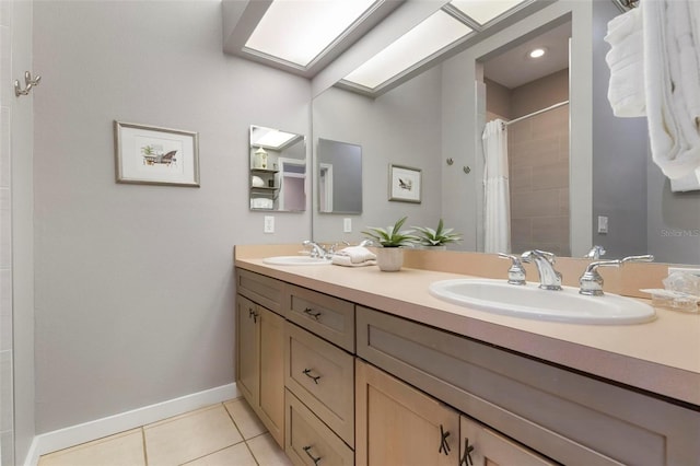 full bathroom featuring tile patterned floors, a skylight, baseboards, and a sink