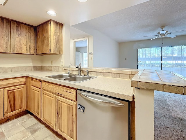 kitchen with kitchen peninsula, a textured ceiling, ceiling fan, stainless steel dishwasher, and sink