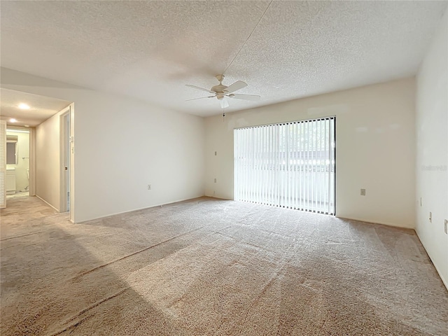 carpeted spare room with a textured ceiling and ceiling fan