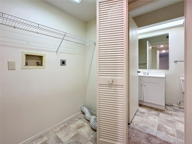 clothes washing area featuring washer hookup, hookup for an electric dryer, light tile patterned floors, and sink