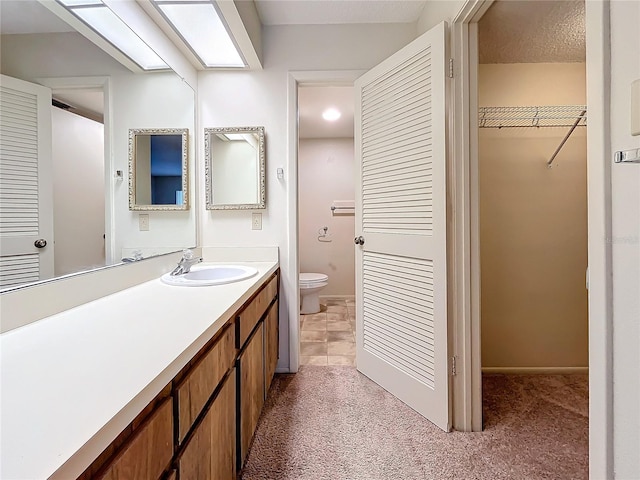 bathroom featuring vanity, toilet, and a textured ceiling