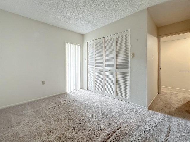 unfurnished bedroom with light carpet, a textured ceiling, and a closet