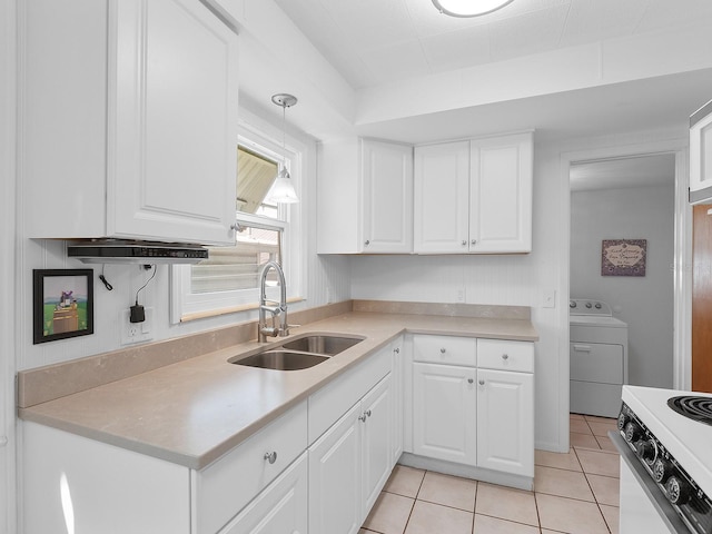 kitchen with white stove, white cabinetry, light tile patterned floors, sink, and washer / dryer