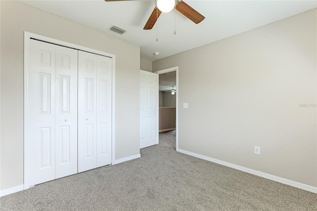 unfurnished bedroom with ceiling fan, a closet, and carpet flooring