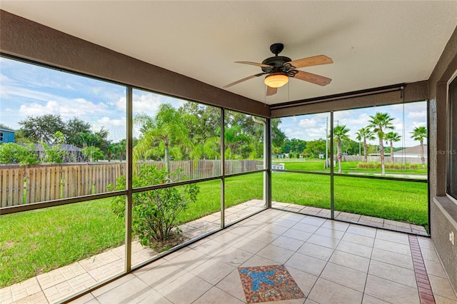 unfurnished sunroom featuring ceiling fan